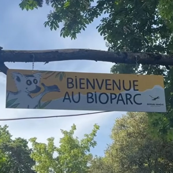 Photo de l'entrée du Bioparc Genève montrant une pancarte "Bienvenue au Bioparc"